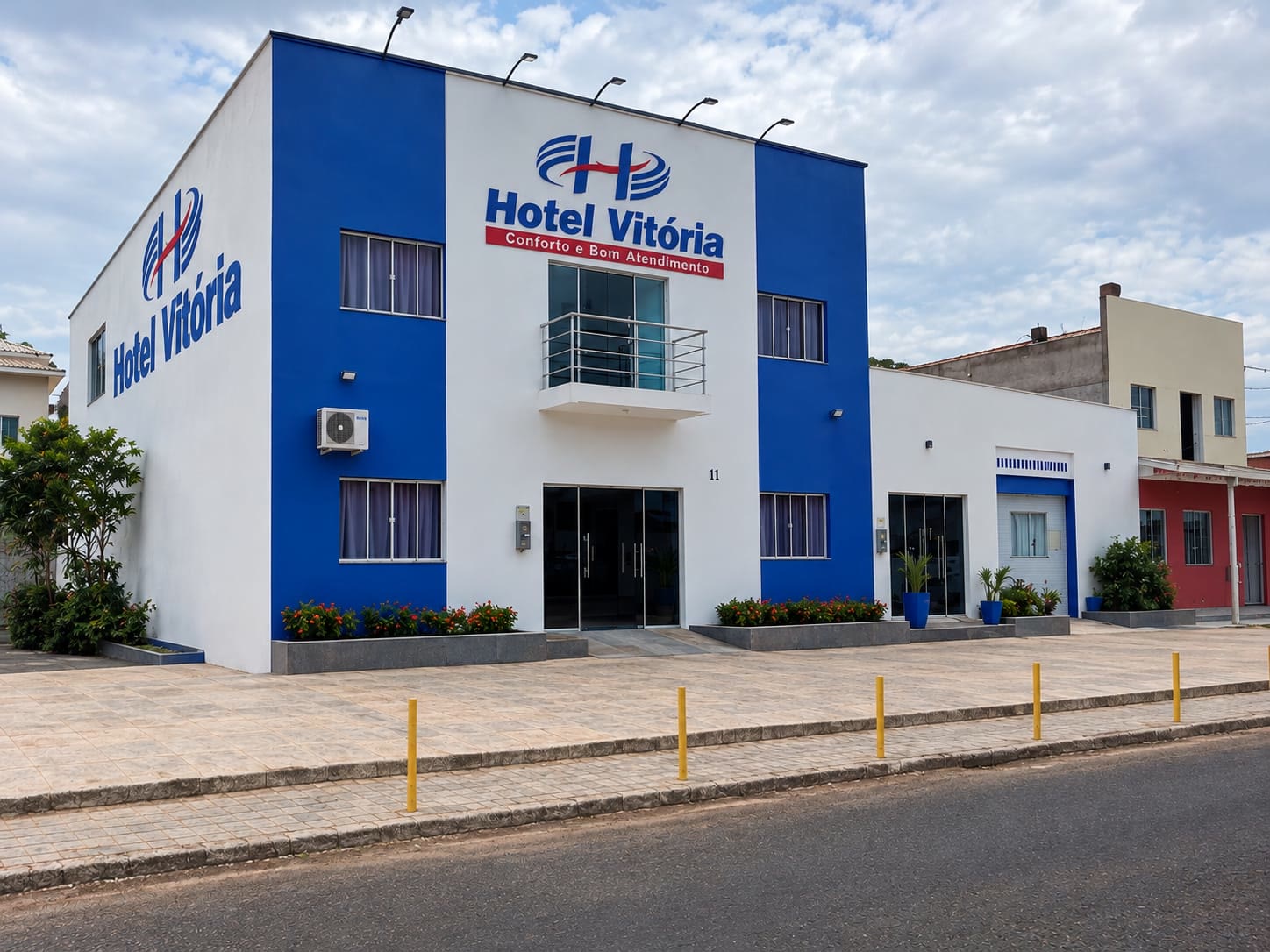 Fachada do Hotel Vitória, prédio azul e branco com o letreiro Conforto e Bom Atendimento